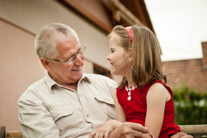 Natural portrait of grandfather with her grandchild ouside in backyard. Natural portrait of grandfather with her grandchild ouside in backyard