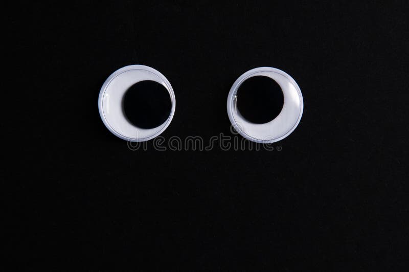 Two big google eyes on a black background