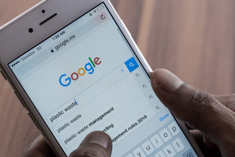 Man using Google Web Search on Smart Phone. Photo of iPhone with a Google search app running.