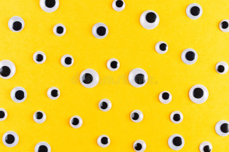 Googly plastic eyes pattern on yellow backgroud. Used for imitation of eyeballs for handcraft toys and dolls and others creativity. Flat lay. Googly plastic eyes pattern on yellow backgroud. Used for imitation of eyeballs for handcraft toys and dolls and others creativity. Flat lay