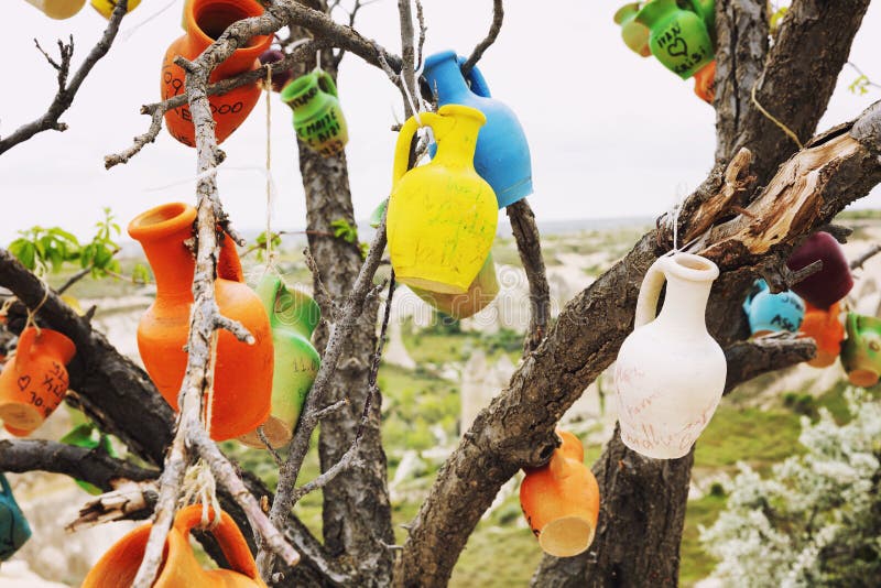 Goreme, Kappadokien, 05/11.2019: Ein wunderschöner Baum, der mit Tontöpfen mit verschiedenen Unterschriften von Touristen geschmü lizenzfreies stockfoto Goreme, Kappadokien, 05/11.2019: Ein wunderschöner Baum, der mit Tontöpfen mit verschiedenen Unterschriften von Touristen geschmü lizenzfreies stockfoto