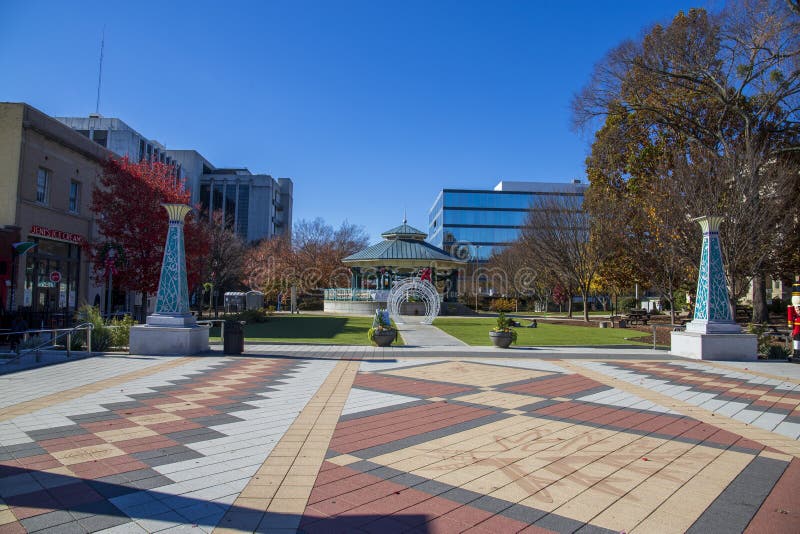 A gorgeous autumn landscape at the Decatur Square with red and yellow autumn trees, lush green trees and a round blue pergola