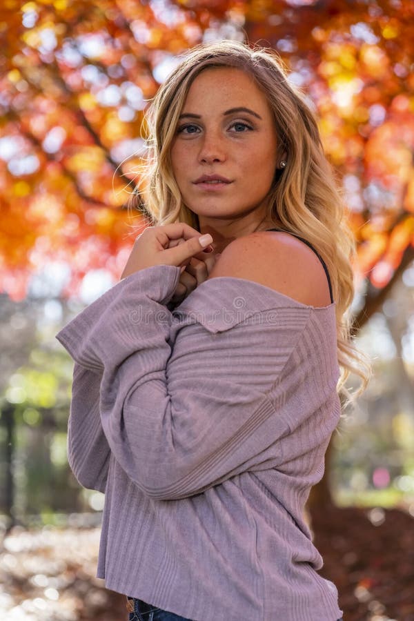 A Lovely Blonde Model Enjoys An Autumn Day Outdoors At The Park Stock