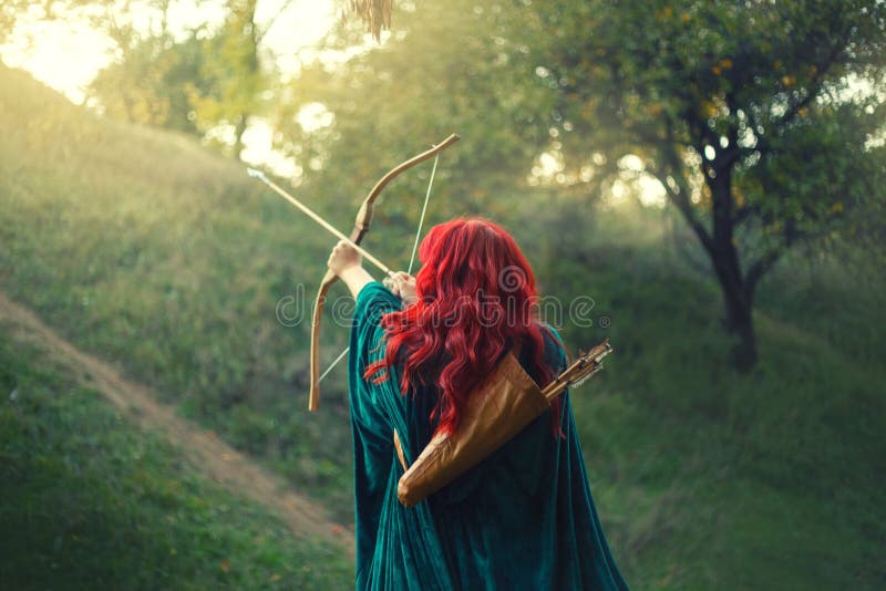 Gorgeous huntress pushing her last light to the sun, waiting for salvation during terrible danger, red-haired girl fights bravely for life, emerald velvet cloak, photo without a face from the back.