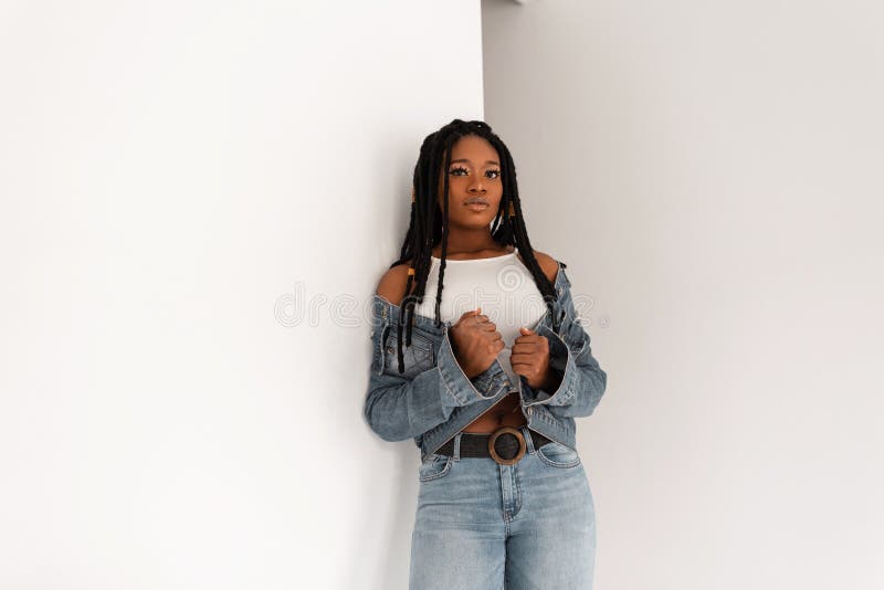 Gorgeous Modern African American Woman in Trendy Top in Stylish Blue Jeans  in Shoes with Cool Long Dreadlocks Stands Near Stock Image - Image of girl,  collection: 245282817