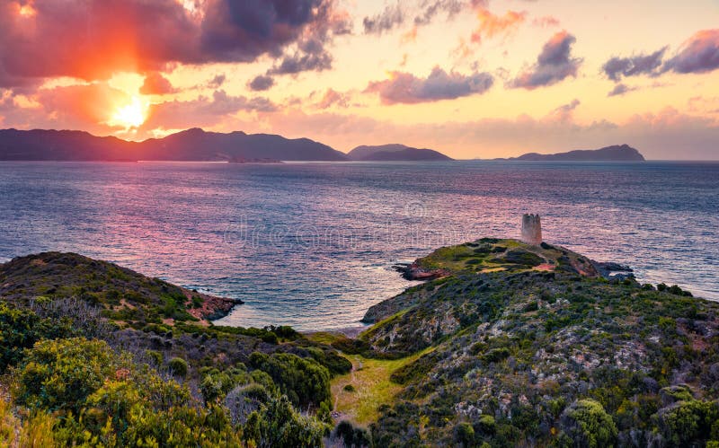 Gorgeous sunset view of Piscinni bay with Torre di Pixinni tower on background. Fantastic evening scene of Sardinia island, Italy