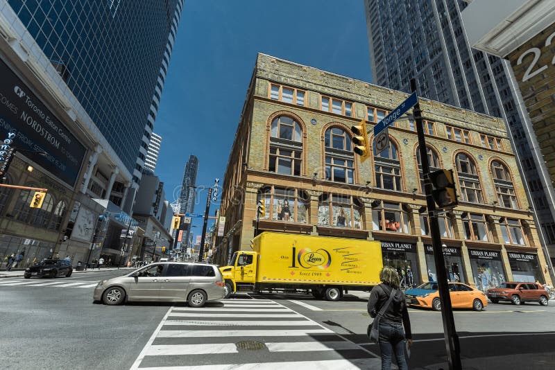 Gorgeous wide open view of Toronto young street with fragment of old and modern buildings, walking people and various trucks royalty free stock images