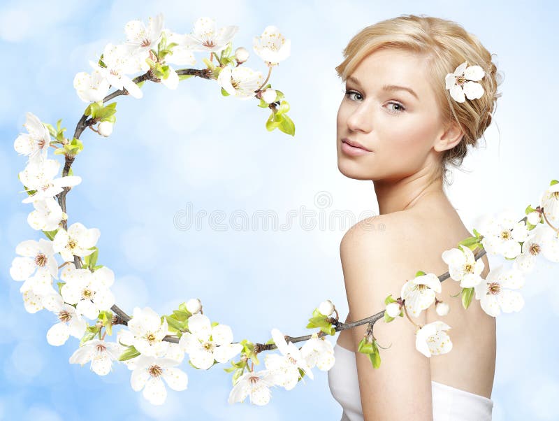 Gorgeous young blond woman with spring flower branch