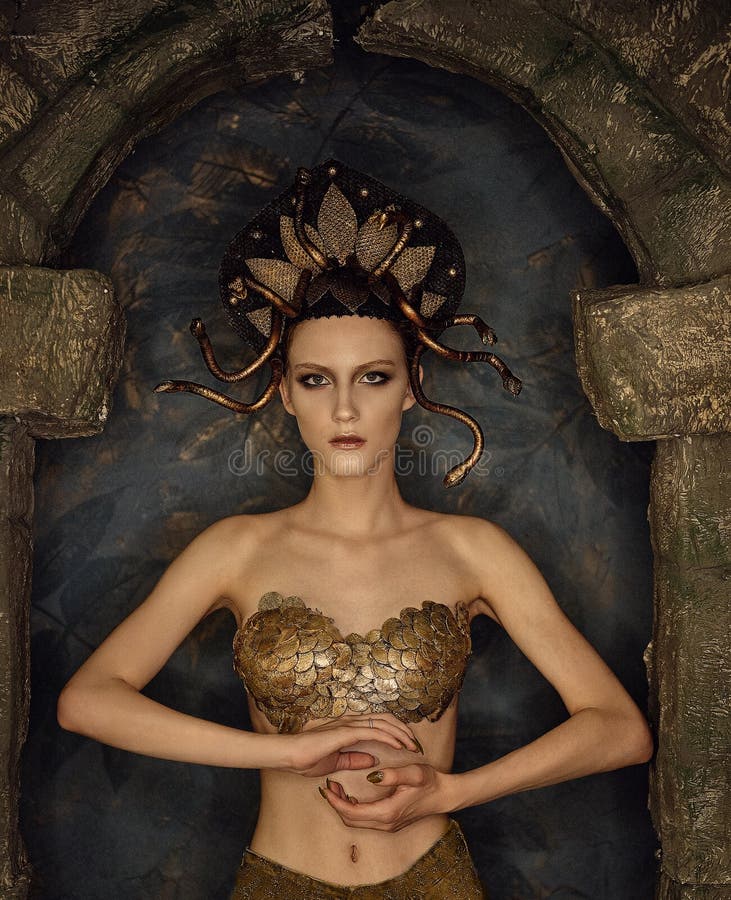 Gorgon das medusa do traje da menina com o sutiã do ouro das escalas em um arco de pedra