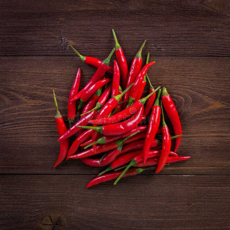 Gorący chili pieprz na ciemnym drewnianym tle, odgórny widok obraz stock Gorący chili pieprz na ciemnym drewnianym tle, odgórny widok obraz stock