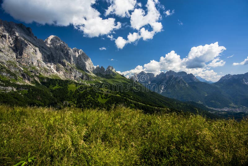 Dolomite mountains and Alps peaks with green meadows and rock spiers among woods and alpine pastures at an alpine hut in Gossaldo Belluno in the Belluno Dolomites Vicenza Veneto Italy. Dolomite mountains and Alps peaks with green meadows and rock spiers among woods and alpine pastures at an alpine hut in Gossaldo Belluno in the Belluno Dolomites Vicenza Veneto Italy