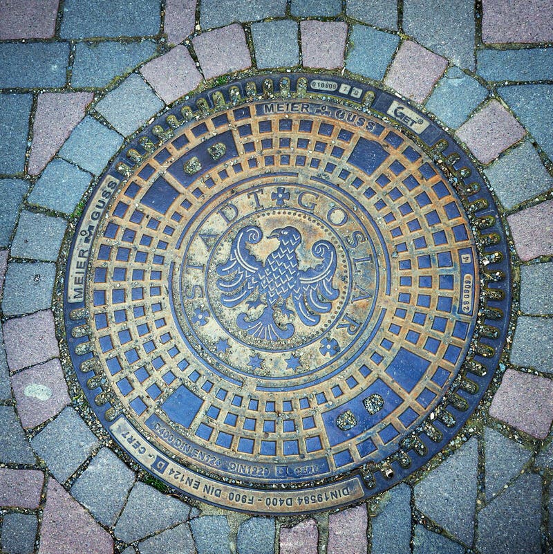 Goslar, Germany - April 21, 2016: Emblem of city Goslar on an iron manhole cover. Goslar, Germany - April 21, 2016: Emblem of city Goslar on an iron manhole cover