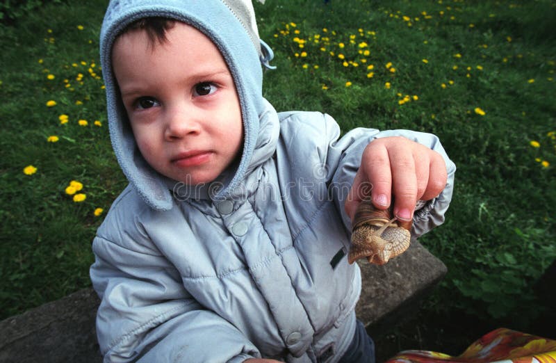 Gosse affichant l'escargot image libre de droits Gosse affichant l'escargot image libre de droits
