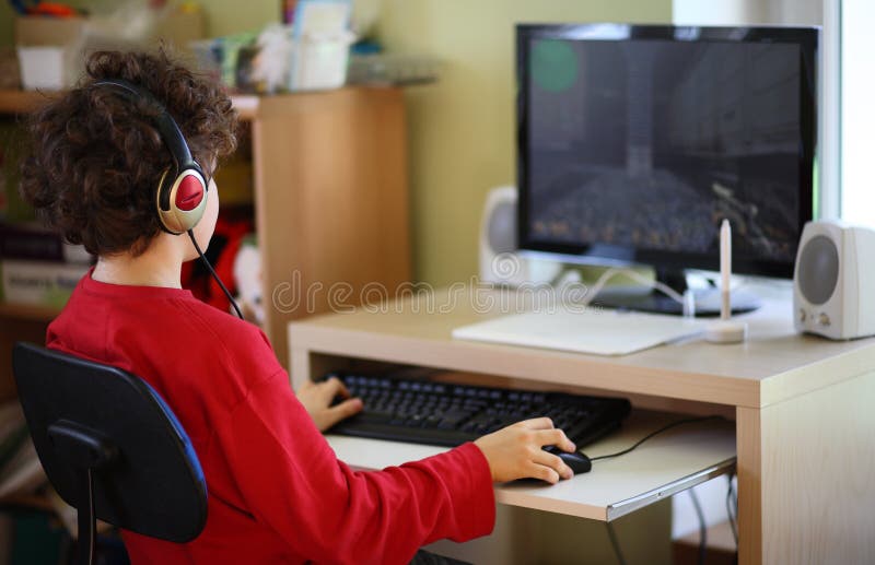 Gosse utilisant l'ordinateur photographie stock libre de droits Gosse utilisant l'ordinateur photographie stock libre de droits