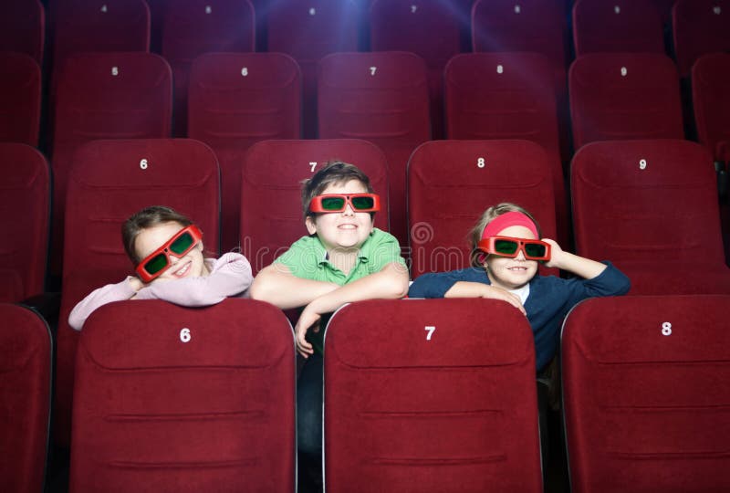 Smiling kids watching cartoons at the cinema. Smiling kids watching cartoons at the cinema