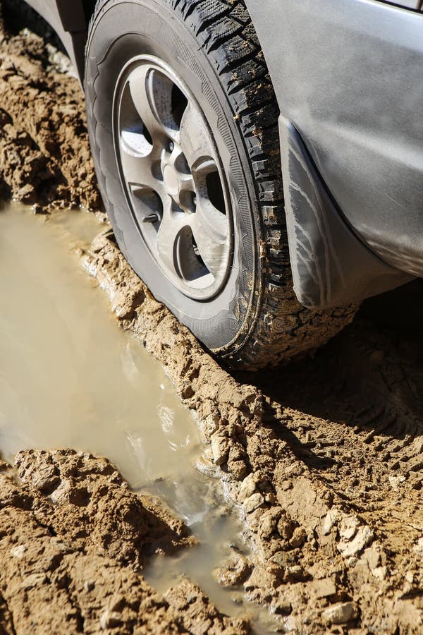 Car Stuck in the Mud Car Wheel in Dirty Puddle Rough Terrain Stock