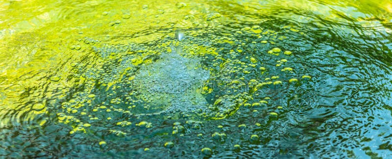 Gota de agua y burbujas en una fuente fresca de agua verde foto de archivo