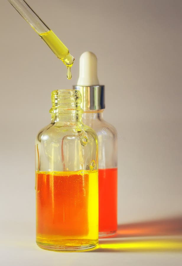 a gota do óleo cosmético útil deixa-me cair de uma pipeta transparente imagens de stock a gota do óleo cosmético útil deixa-me cair de uma pipeta transparente imagens de stock