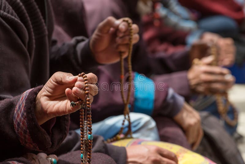 Gotas budistas en las manos de los peregrinos tibetanos que ruegan en el monasterio de Lamayuru, Ladakh