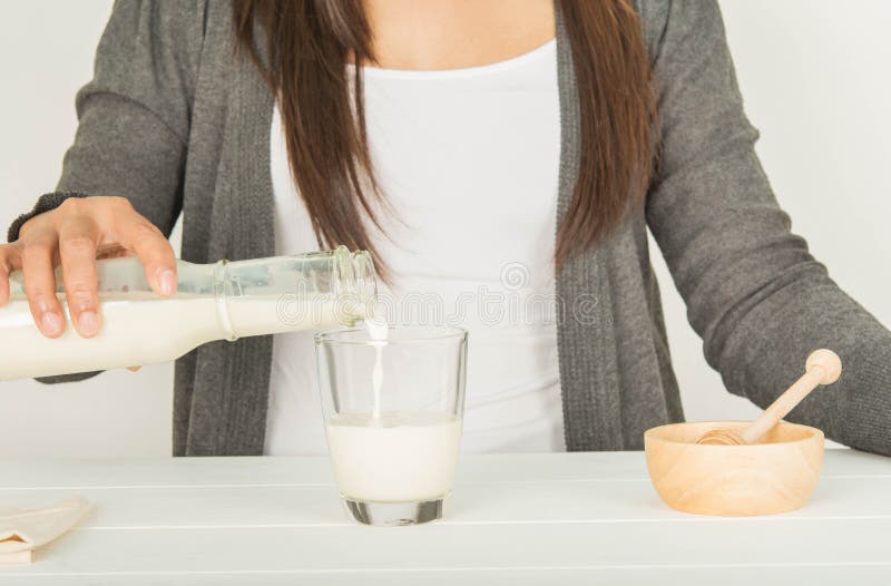 Gotas de la miel sobre un vidrio de leche imagen de archivo libre de regalías Gotas de la miel sobre un vidrio de leche imagen de archivo libre de regalías