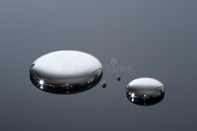 Gotas do mercúrio em uma superfície reflexiva fotografia de stock Gotas do mercúrio em uma superfície reflexiva fotografia de stock