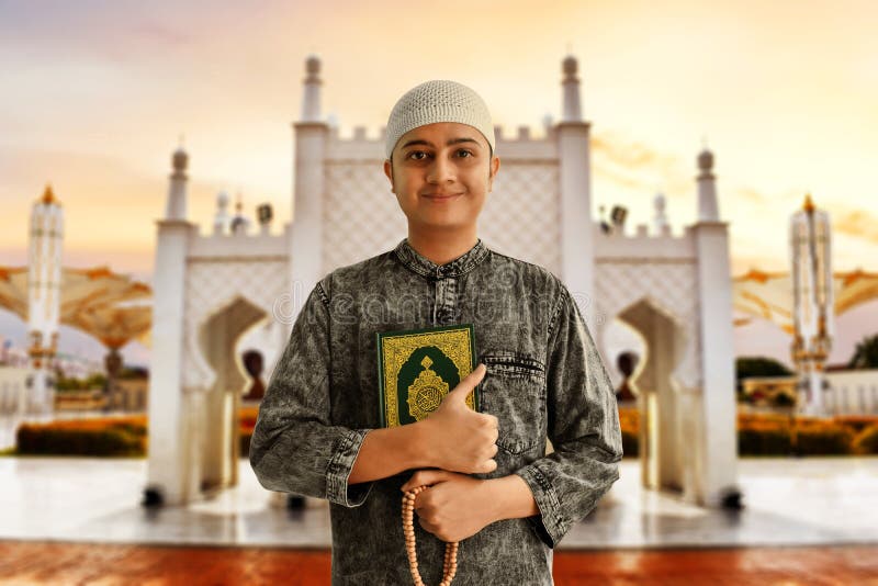 Gotas musulmanes asiáticas religiosas del quran y del rosario de la tenencia del hombre foto de archivo Gotas musulmanes asiáticas religiosas del quran y del rosario de la tenencia del hombre foto de archivo