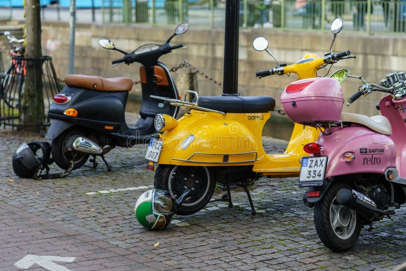 Vespa like view 3 different color scooter style motor parked near Centre Train Station of Gothenburg