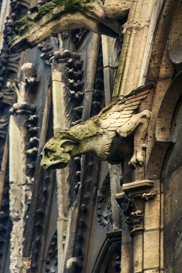 Gothic gargoyles covered with moss on the facade of the famous Notre Dame de Paris Cathedral in Paris France
