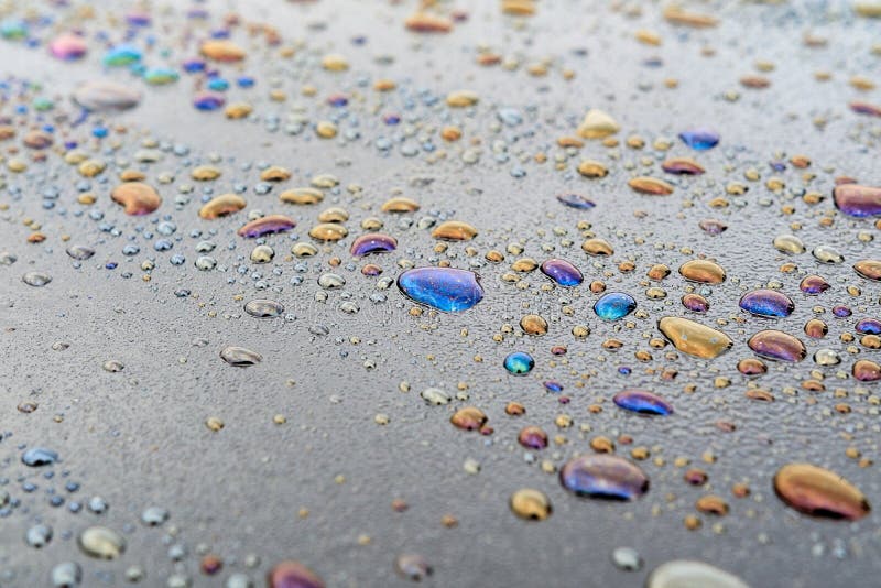 Gotitas de agua y productos derivados del petróleo en la superficie oscura, puntos coloreados en la superficie imagenes de archivo Gotitas de agua y productos derivados del petróleo en la superficie oscura, puntos coloreados en la superficie imagenes de archivo