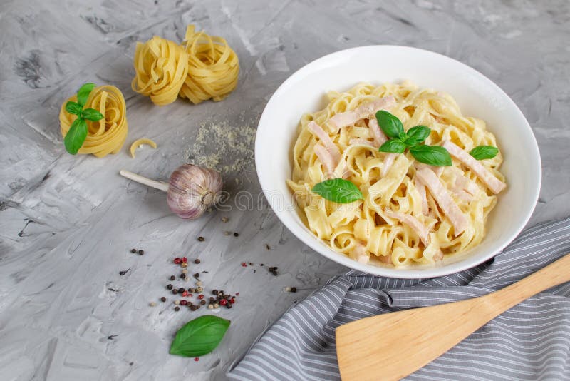 Gotujący tagliatelle makaron na talerzu z Carbonara kumberlandem, bekonem, basilem i Parmezańskim serem, Włochy jedzenie fotografia royalty free Gotujący tagliatelle makaron na talerzu z Carbonara kumberlandem, bekonem, basilem i Parmezańskim serem, Włochy jedzenie fotografia royalty free