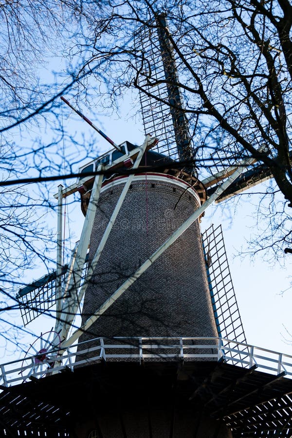 Gouda, Holanda sul/Países Baixos - 20 de janeiro de 2019: Imagem do moinho de vento velho ao lado do parque da cidade tomado atra imagens de stock Gouda, Holanda sul/Países Baixos - 20 de janeiro de 2019: Imagem do moinho de vento velho ao lado do parque da cidade tomado atra imagens de stock