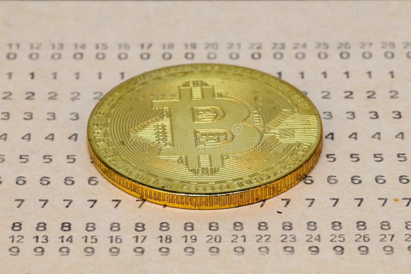 Bitcoin lying on punched card, exchange of currencies concept. Bitcoin lying on punched card, exchange of currencies concept