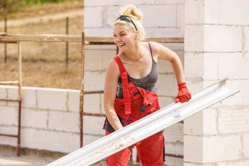 Goutti?re de transport de femme sur le chantier de construction image stock Goutti?re de transport de femme sur le chantier de construction image stock