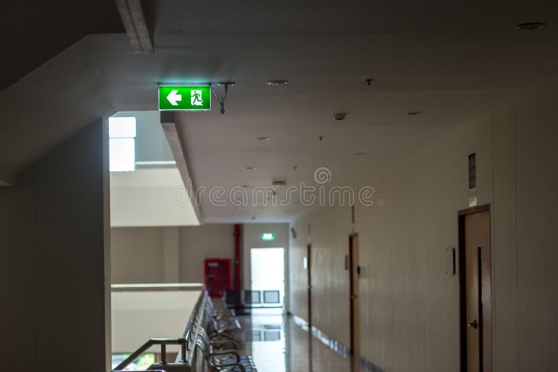 Gr?nt tecken f?r n?d- utg?ng som visar v?gen att fly Brandutg?ng i byggnaden arkivfoton Gr?nt tecken f?r n?d- utg?ng som visar v?gen att fly Brandutg?ng i byggnaden arkivfoton