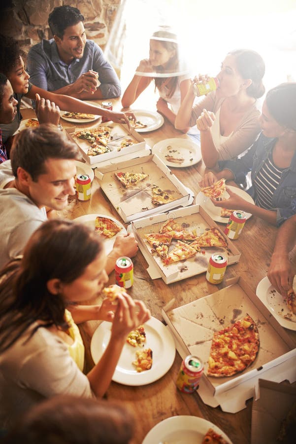 Grab a slice and let the good times roll. a group of friends enjoying pizza together.