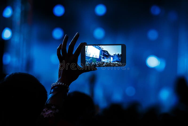 Grabación de vídeo del concierto en el teléfono del smartphone del partido de la playa fotos de archivo libres de regalías Grabación de vídeo del concierto en el teléfono del smartphone del partido de la playa fotos de archivo libres de regalías