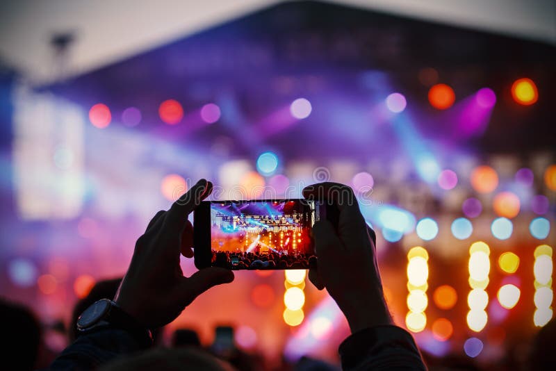 Grabación del vídeo y de la foto del concierto por smartphone imagen de archivo libre de regalías Grabación del vídeo y de la foto del concierto por smartphone imagen de archivo libre de regalías