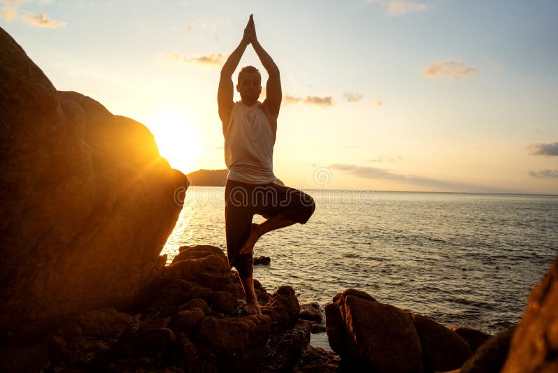 Grabb som g? r yoga p? solnedg? ngen vid havet royaltyfria bilder