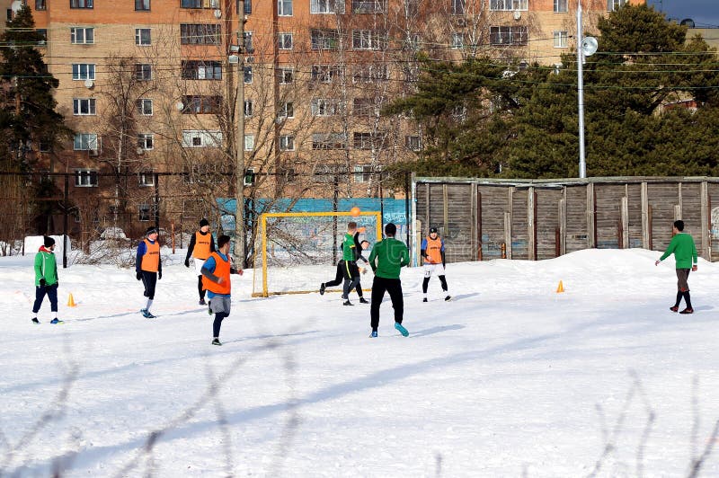 Grabbar spelar fotboll p? ett f?lt som t?ckas med sn? fotografering för bildbyråer Grabbar spelar fotboll p? ett f?lt som t?ckas med sn? fotografering för bildbyråer