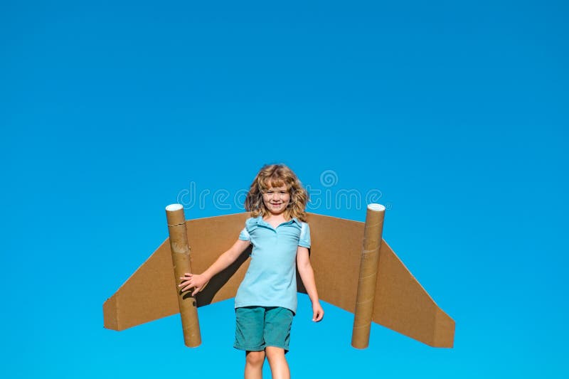 Grabbens fantasi drömmer om en liten pilot och flyga på vingar från jetpacket. Ett lyckligt barn leker med en leksaksport. pilot p royaltyfri foto