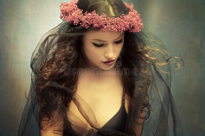 Ladný mladá žena veniec z kvety a čierny závoj.