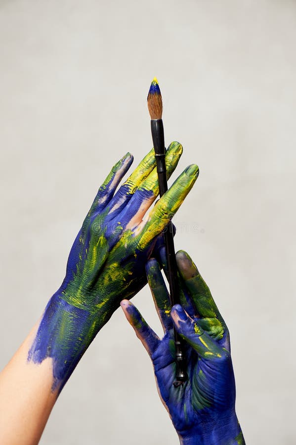 Graceful Hands Of The Artist With A Brush Hands In Blue And Yellow