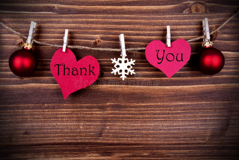 The Words Thank You on two Heart with Christmas or Winter Decoration Hanging on a Line on Wooden Background, with Copy Space. The Words Thank You on two Heart with Christmas or Winter Decoration Hanging on a Line on Wooden Background, with Copy Space