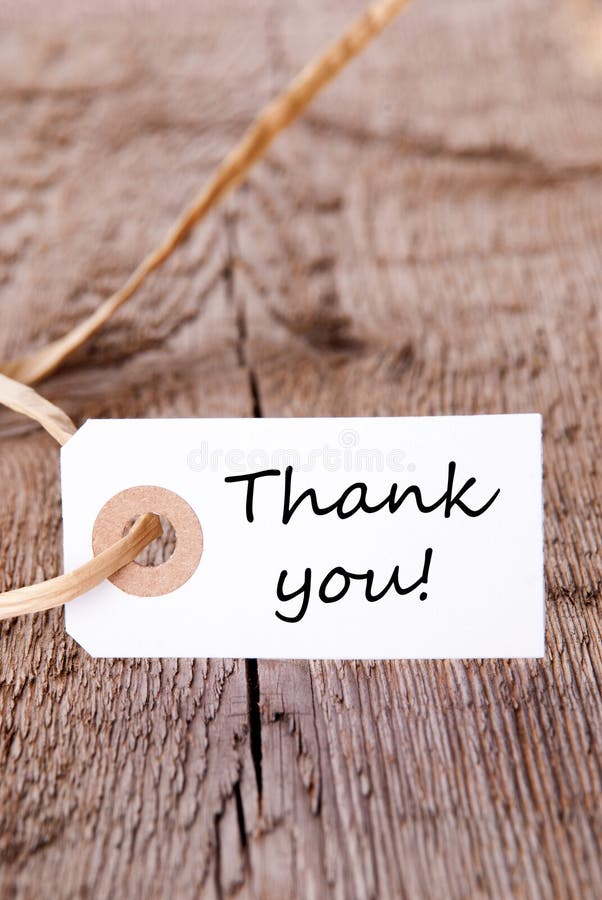 The Words Thank You on a White Label on a wooden Plank. The Words Thank You on a White Label on a wooden Plank