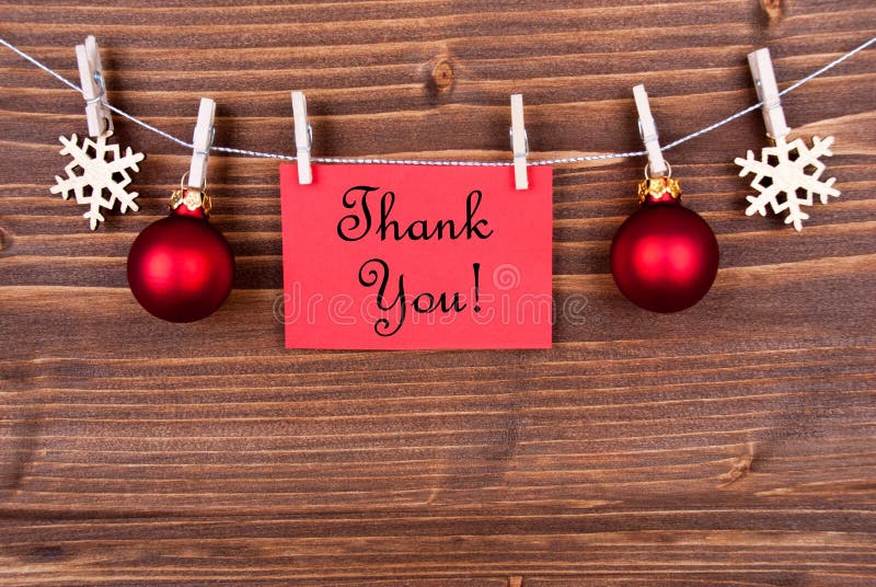 Thank You on a Red Label Hanging on a Line with Christmas or Winter Decoration. Thank You on a Red Label Hanging on a Line with Christmas or Winter Decoration