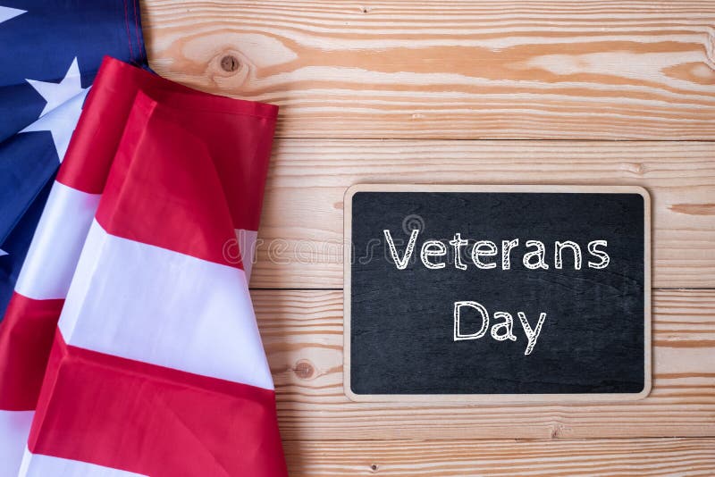 Gracias texto de los veteranos escrito en pizarra con la bandera de los Estados Unidos de América en fondo de madera imagen de archivo Gracias texto de los veteranos escrito en pizarra con la bandera de los Estados Unidos de América en fondo de madera imagen de archivo