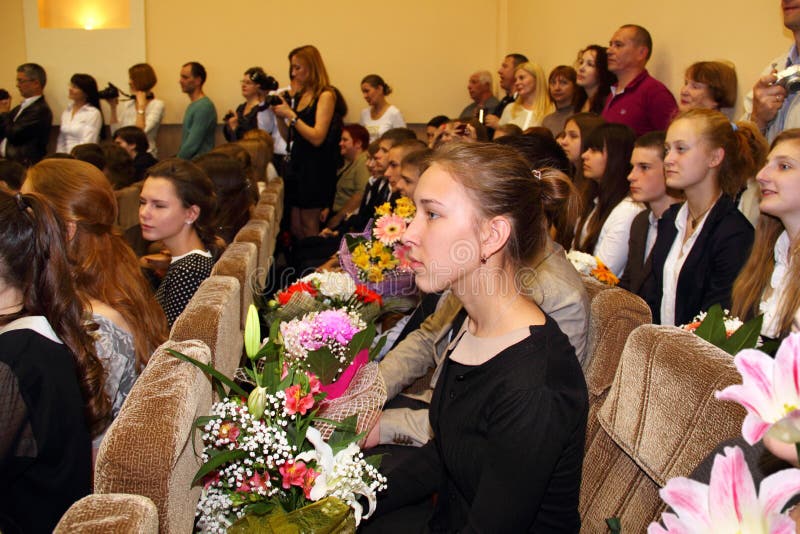 Graduates of the general education school celebrating the end of schooling and receiving diplomas. In the assembly hall are children and their parents, as well as teachers. Picture taken in Minsk, Belarus. Graduates of the general education school celebrating the end of schooling and receiving diplomas. In the assembly hall are children and their parents, as well as teachers. Picture taken in Minsk, Belarus.