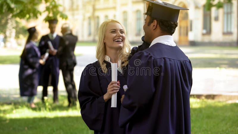 Graduados de la universidad que hablan teniendo la diversión, pares del estudiante, amor y relación imagen de archivo Graduados de la universidad que hablan teniendo la diversión, pares del estudiante, amor y relación imagen de archivo