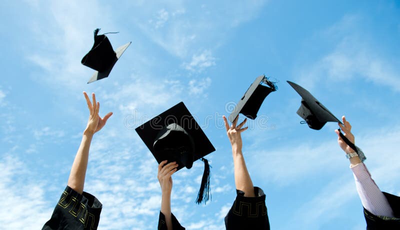 Graduates throwing graduation hats in the air.