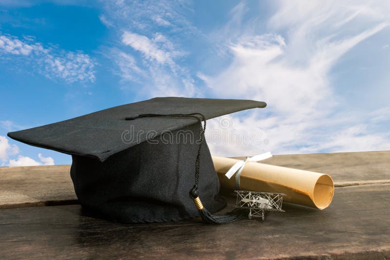 graduation cap, hat with degree paper on wood table, sky background Empty ready for your product display or montage. royalty free stock photography graduation cap, hat with degree paper on wood table, sky background Empty ready for your product display or montage. royalty free stock photography
